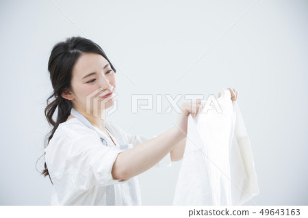 Woman putting on the laundry Woman putting on the laundry 49643163