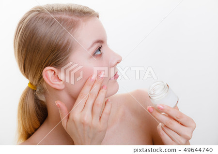 Woman applying face cream with her finger 49644740