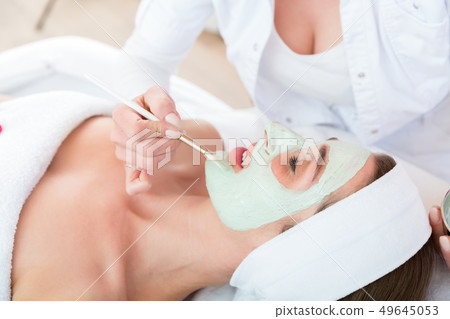 Beautician applying face peeling mask Beautician applying face peeling mask 49645053