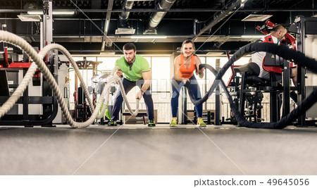 Man and woman exercising at gym Man and woman exercising at gym 49645056