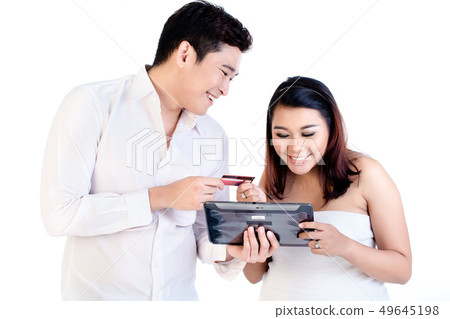 Man and his pregnant wife shopping online using digital tablet 49645198