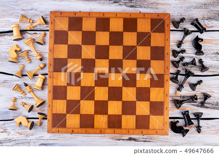 Chess figures lying next to chess board. 49647666