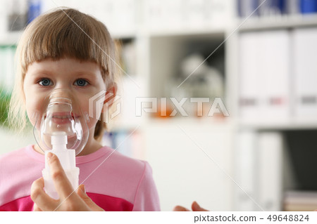 Little girl breathing with inhaler at doctor office Little girl breathing with inhaler at doctor office 49648824