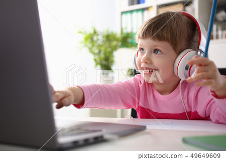 Little girl wearing headphones use mobile computer 49649609
