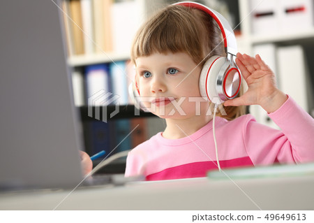 Little girl wearing headphones use mobile computer 49649613