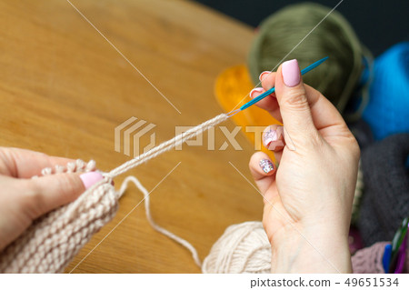 Hands of a young woman knit crochet from beigeyarn Hands of a young woman knit crochet from beigeyarn 49651534