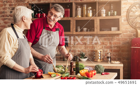 Senior man and woman cooking healthy lunch together in kitchen Senior man and woman cooking healthy lunch together in kitchen 49651691