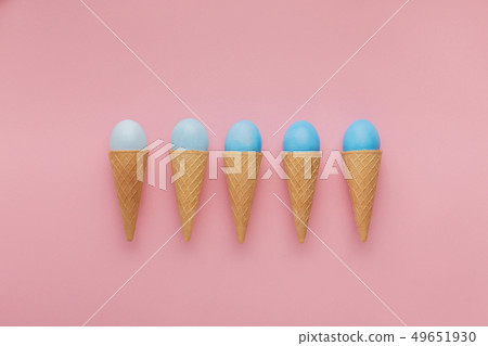 Blue easter eggs in waffle cones on pink background 49651930