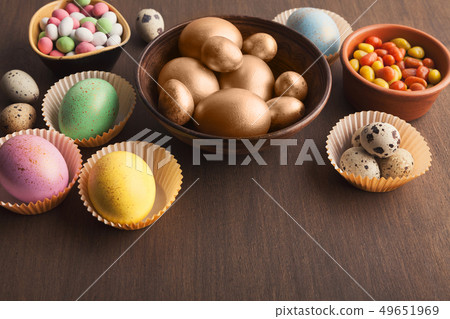 Colourful eggs and candies on dark background 49651969