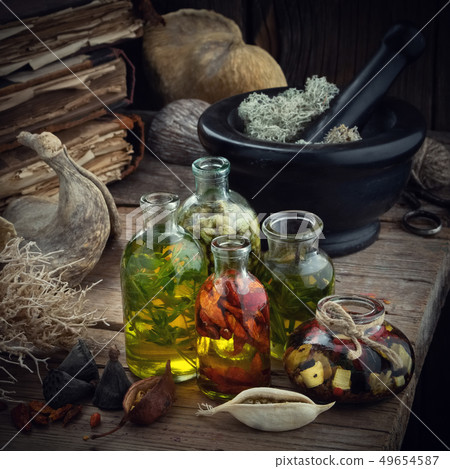 Essential oil bottles, mortar and old books. Essential oil bottles, mortar and old books. 49654587