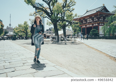 woman walking through japanese temple woman walking through japanese temple 49658842