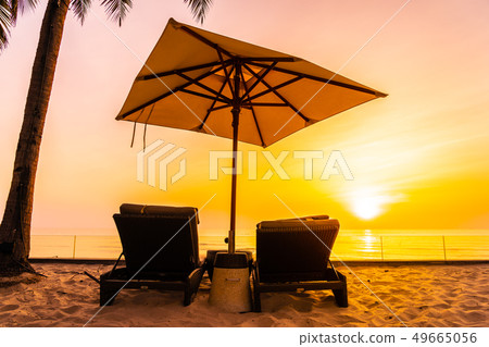 Umbrella and chair on the beautiful beach and sea at sunrise time for travel and vacation Umbrella and chair on the beautiful beach and sea at sunrise time for travel and vacation 49665056