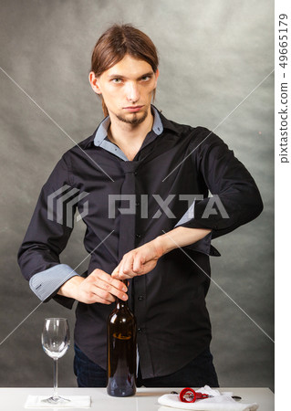 Somellier opening bottle with corkscrew. 49665179