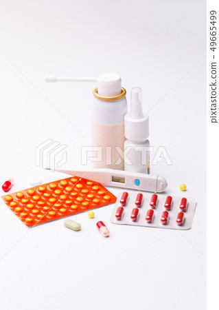 Treatment of flu. Throat spray, nose drops, cold pills and thermometer on white background. 49665499
