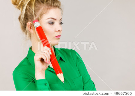 Woman confused thinking, big pencil in hand 49667560
