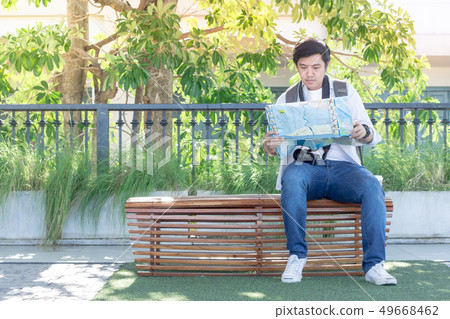 Men are planning a trip to see the tourist map in Men are planning a trip to see the tourist map in 49668462