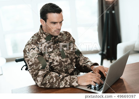 Serious Military Man Uses Notebook in Living Room Serious Military Man Uses Notebook in Living Room 49669397
