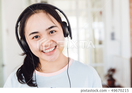 Asian cute young teen smiling with headphone enjoy Asian cute young teen smiling with headphone enjoy 49670215