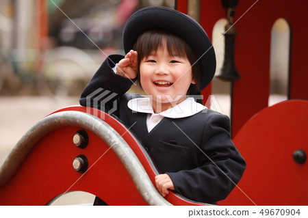 Kindergarten children who ride on playground equipment and salute 49670904