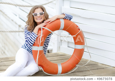 Sexy girl against wooden wall in the form of sailors with a lifeline and a cap. Shooting in the 49673078