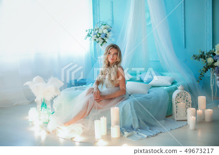 Boudoir photography. Woman blonde with long hair in lingerie on the bed surrounded by flowers tulips Boudoir photography. Woman blonde with long hair in lingerie on the bed surrounded by flowers tulips 49673217