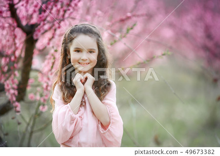 Beautiful young woman in pinkstylish garden dress blooming sakura Beautiful young woman in pinkstylish garden dress blooming sakura 49673382