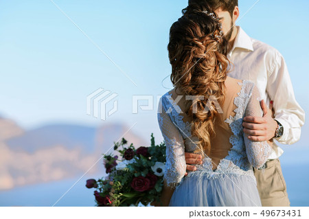 Wedding couple at breathtaking landscape with rock and sea 49673431