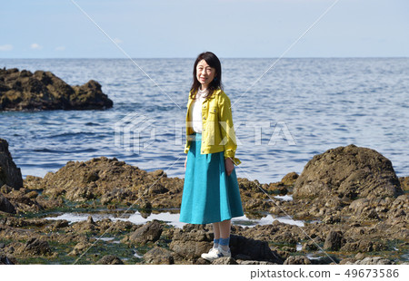 Shot a portrait of a woman with black hair in a yellow jacket and blue skirt on the coast of Isona Mayor, Setana, Hokkaido Shot a portrait of a woman with black hair in a yellow jacket and blue skirt on the coast of Isona Mayor, Setana, Hokkaido 49673586