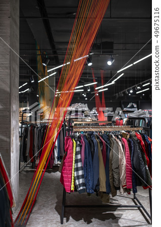 Modern clothes shop with large selection of different wear and shoes Modern clothes shop with large selection of different wear and shoes 49675116