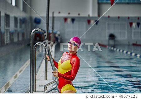 Portrait of a smiling woman swimmer in red yellow Portrait of a smiling woman swimmer in red yellow 49677128