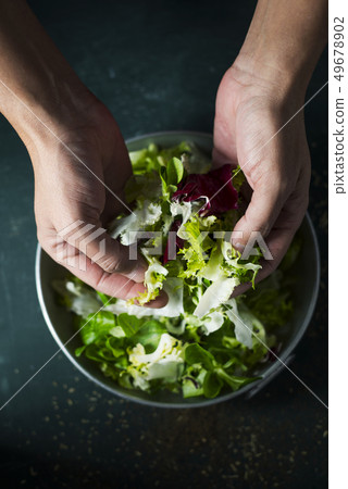 young caucasian man preparing a salad young caucasian man preparing a salad 49678902