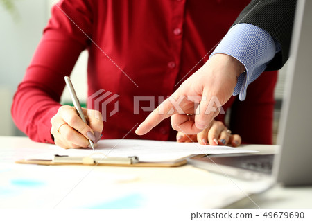 Female employee holding silver pen making notes in documents 49679690