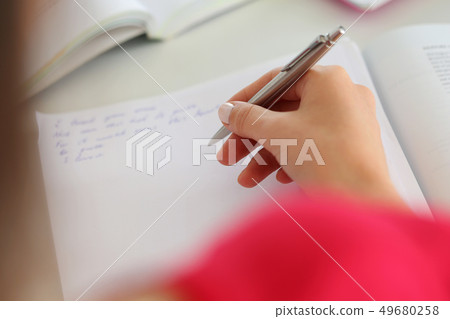 Female hand holding silver pen closeup 49680258