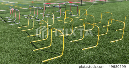 Hurdles set up on turf field for strength and 49680399