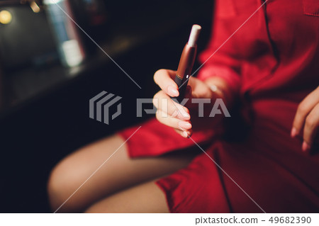 Electronic cigarettes, technology cigarette. Tobacco system IQOS. Female hand on blurred background Electronic cigarettes, technology cigarette. Tobacco system IQOS. Female hand on blurred background 49682390