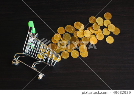 Gold coin money out of shopping trolley and on 49682929