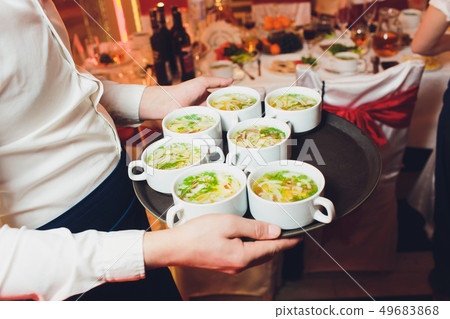 Close up of waiter serving food in a restaurant. Soft focus. 49683868