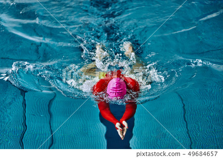 Female athlete in a red-yellow swimsuit 49684657