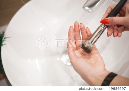 Makr up brush. Woman washing dirty makeup brush with soap and foam in the sink Makr up brush. Woman washing dirty makeup brush with soap and foam in the sink 49684697