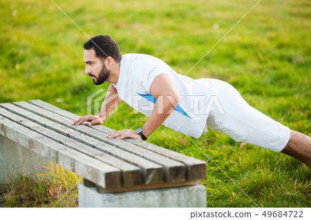 Fitness. Push-up exercise fitness man training arms muscles at outdoor gym Fitness. Push-up exercise fitness man training arms muscles at outdoor gym 49684722