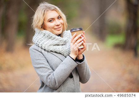 Coffee to go. Young woman with coffee in the autumn park 49685074