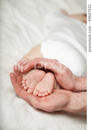Little baby feets on parent hands on white Little baby feets on parent hands on white 49687932