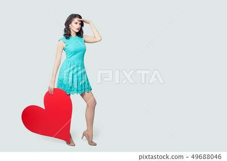 Pretty model holding red heart and looking Pretty model holding red heart and looking 49688046