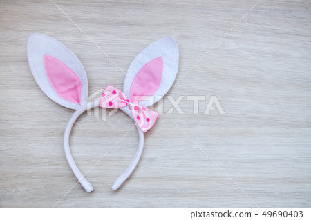 Bunny ears on wooden background. 49690403