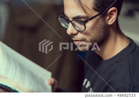 Young computer science student reads an advanced robotics book in Caceres, Spain. 49692533