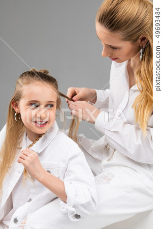 Excited young lady in white jacket talking to her elder sister 49693484