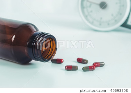 Drug capsule spilled out of bottle on laboratory Drug capsule spilled out of bottle on laboratory 49693508