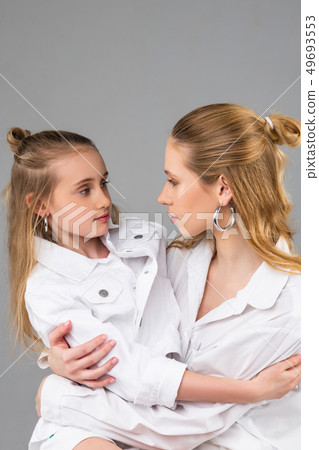 Peaceful good-looking stylish sisters looking deep into eyes 49693553