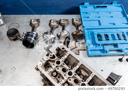 Disassembled engine block is on the table. the mechanic opened the locking valve mechanism. Motor Disassembled engine block is on the table. the mechanic opened the locking valve mechanism. Motor 49700293