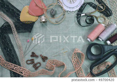 Sewing scene table flat lay composition. Threads, lace, pins, scissors, tape, reel, cloth. Pastel Sewing scene table flat lay composition. Threads, lace, pins, scissors, tape, reel, cloth. Pastel 49700420
